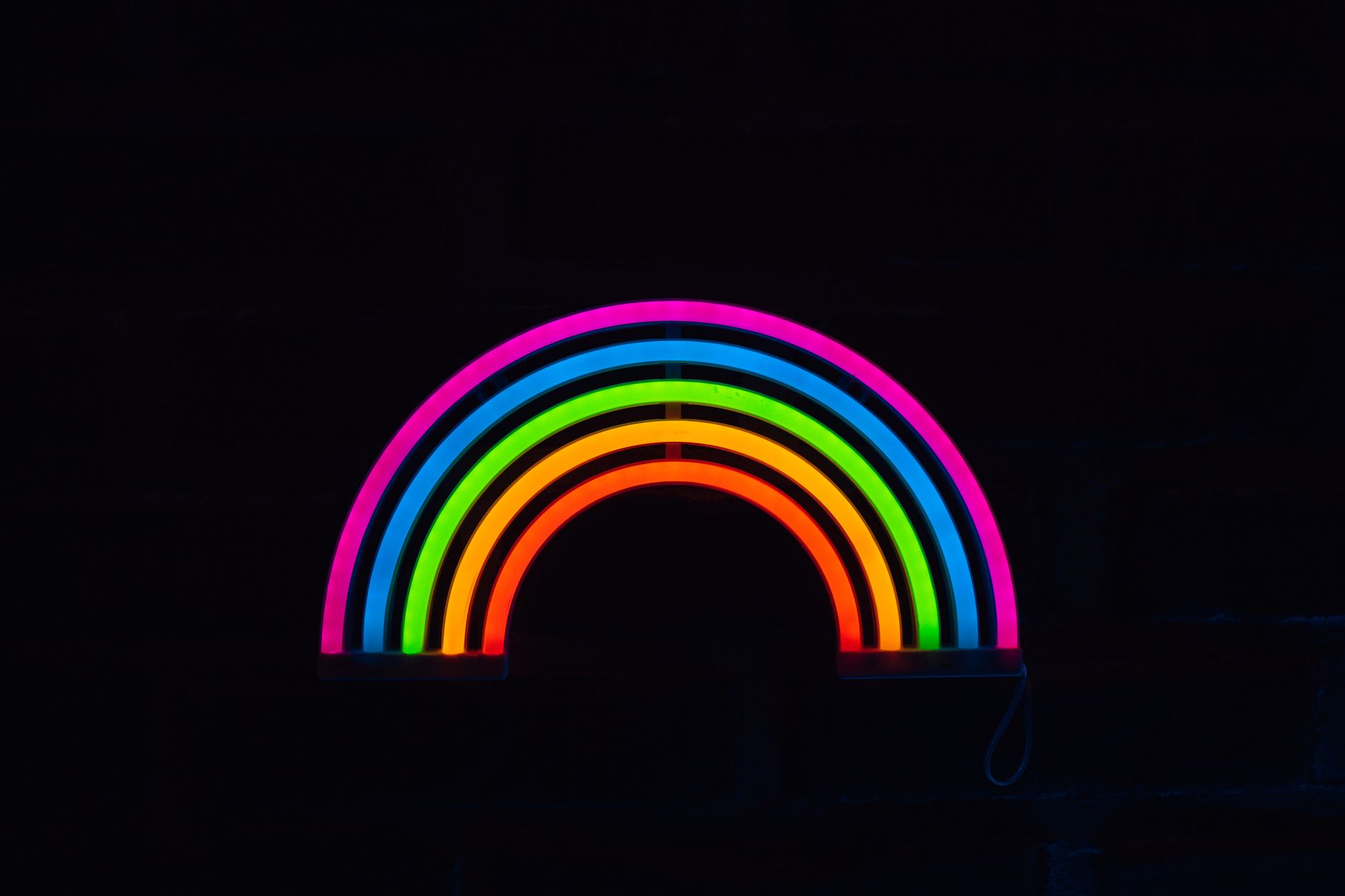A glowing neon rainbow against a dark background, showcasing colorful LED lights.