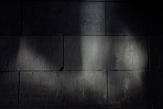 Black and white of background of brick wall of building with shade and light