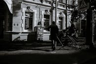 Yard keeper cleaning street of local building