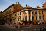 Barriers fencing new asphalt surface of city road near historic residential buildings in classicism style with yellow facade located in Saint Petersburg Russia