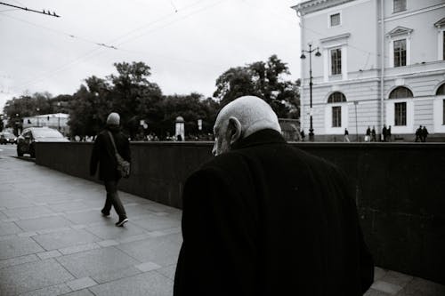 Black and white back view of anonymous senior man and man rising from underpass passage on Nevsky avenue in Saint Petersburg Russia