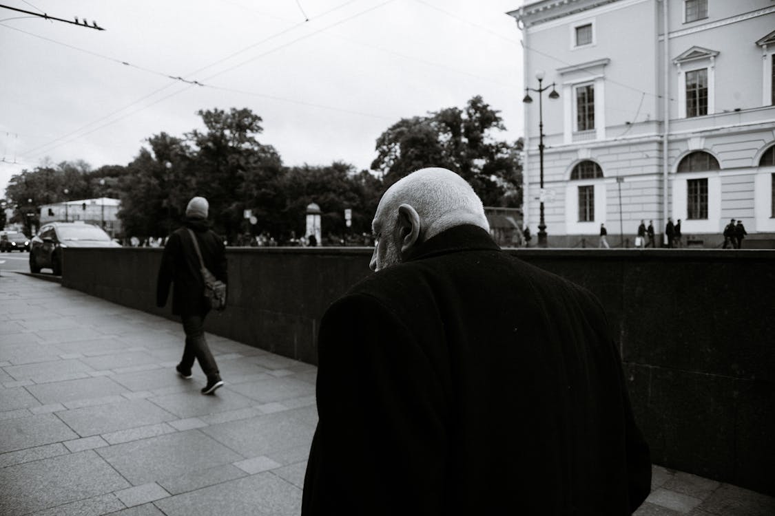 Black and white back view of anonymous senior man and man rising from underpass passage on Nevsky avenue in Saint Petersburg Russia