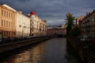 Picturesque scenery of famous historical canal surrounded by aged residential houses and parked cars located in Saint Petersburg Russian Federation before thunderstorm on summer day