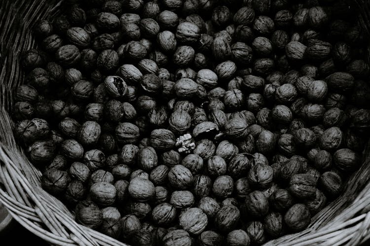 Pile Of Whole Walnuts In Wicker Basket