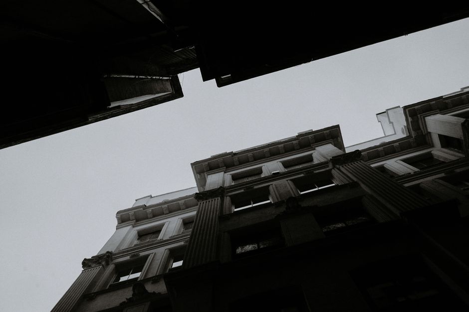 From below black and white of aged multistory masonry house exteriors on city street in daytime