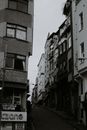 Black and white of aged multistory dwelling building exteriors with inscriptions in city in daytime