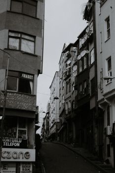 Black and white of aged multistory dwelling building exteriors with inscriptions in city in daytime