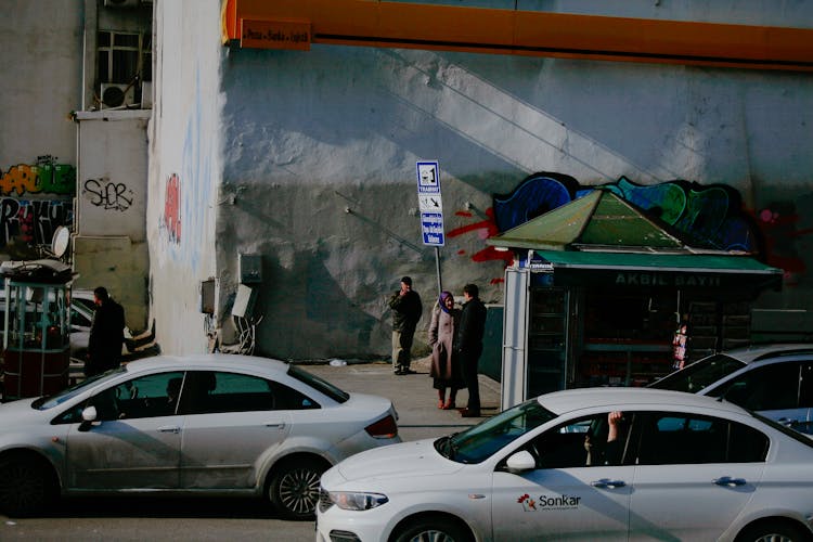 Anonymous People On Bus Stop Near Road With Cars