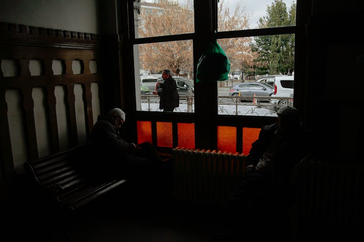 Unrecognizable People On Bench In Old Building