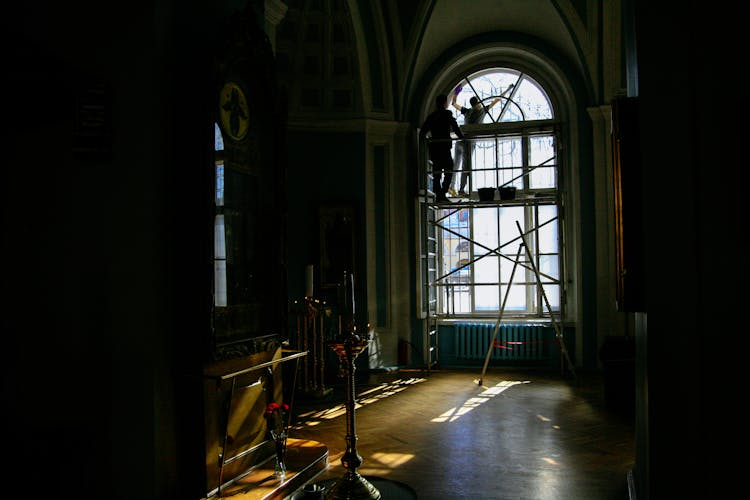 Unrecognizable Workers On Scaffold Near Window Reconstructing Old Building