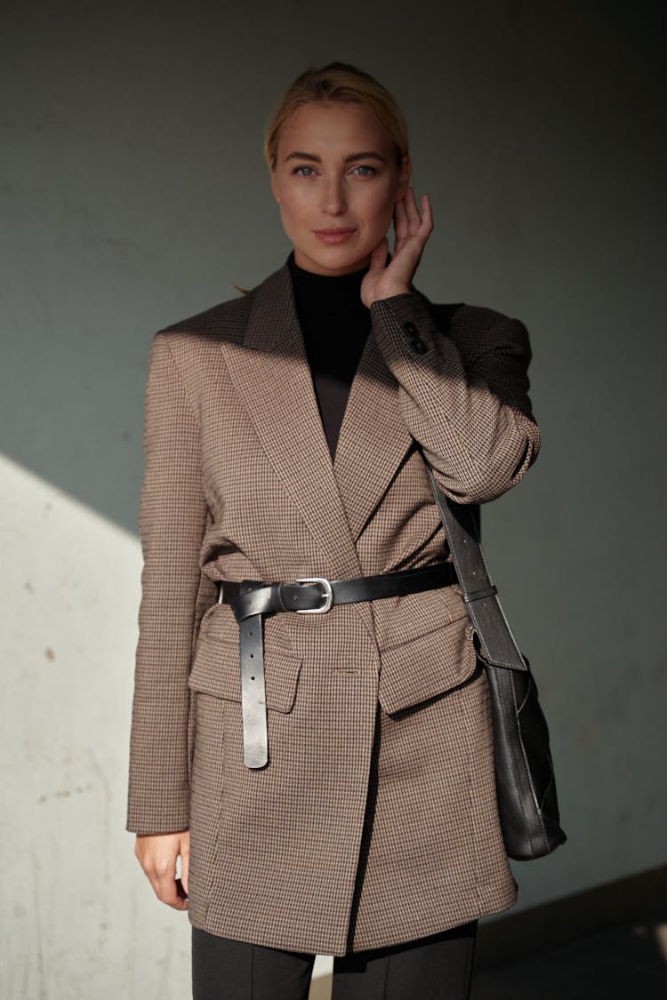 Woman In Brown Blazer With Hand On Cheek