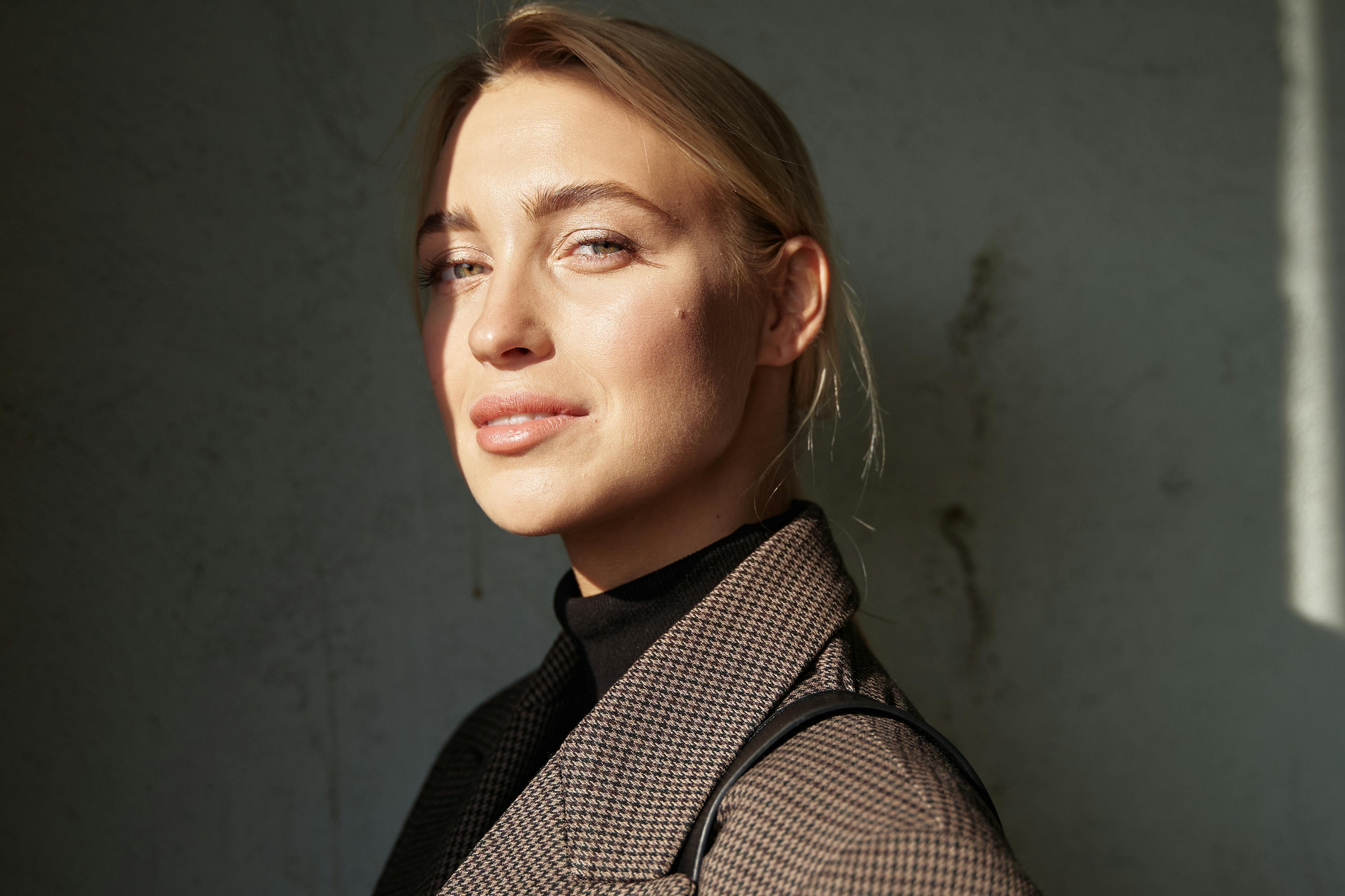 一个自信的女人的引人注目的爆头，柔和的光线和阴影