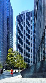 A vibrant urban scene featuring towering skyscrapers and a hint of nature on a bright day.