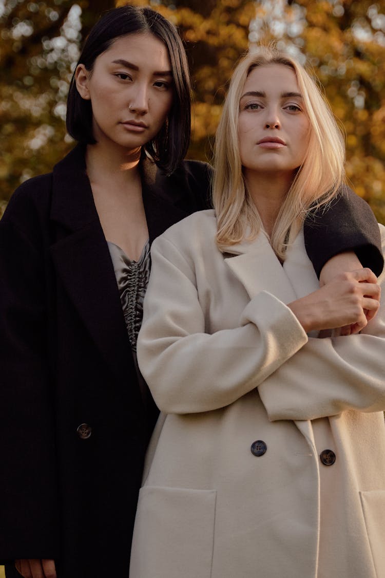 Women In Trench Coats Standing Together