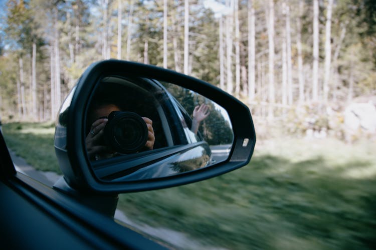 Faceless Woman Taking Photo Through Car Mirror