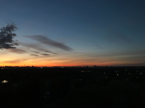 Free Silhouette of city skyline against a vibrant twilight sky with colorful sunset hues. Stock Photo