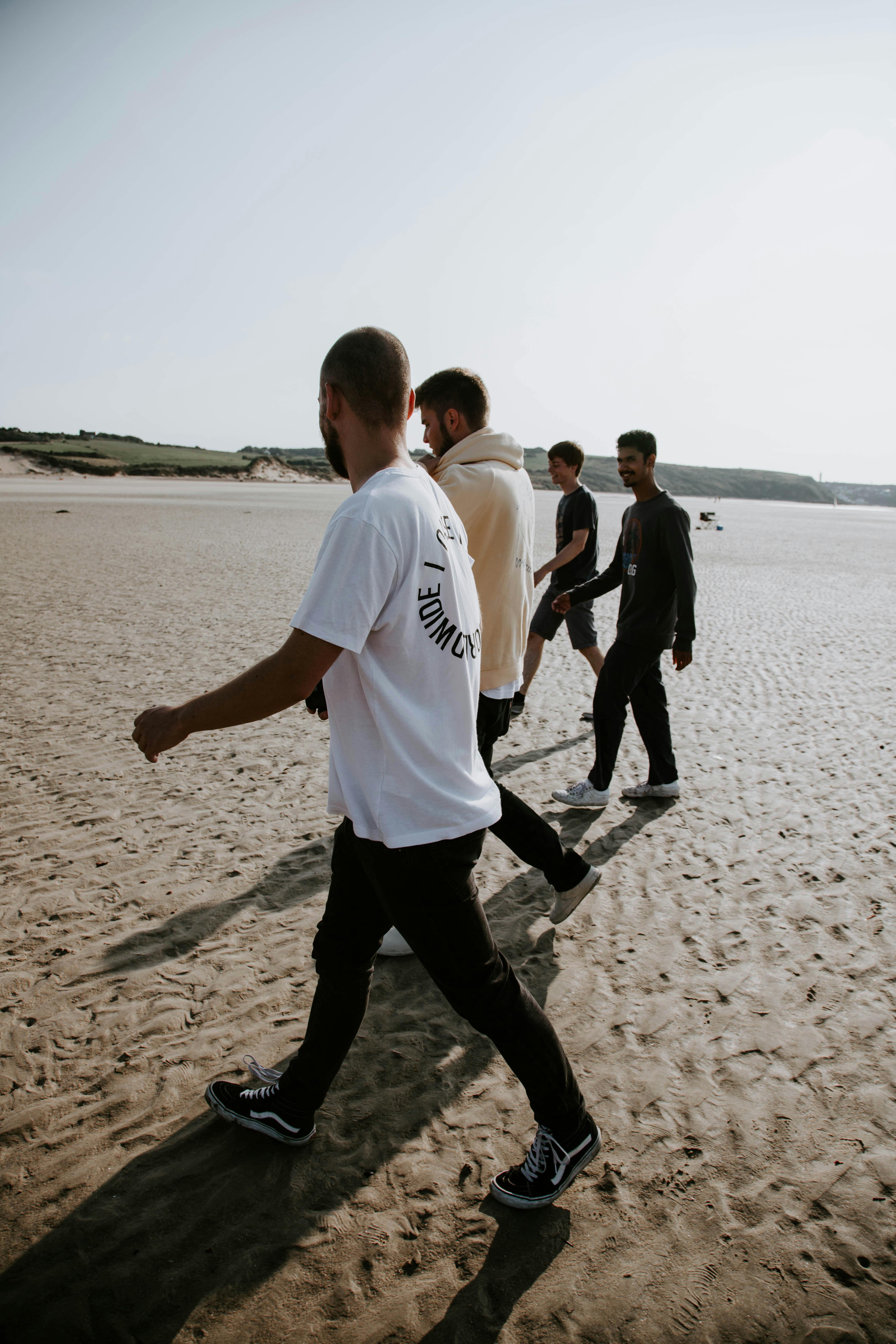 group of men strolling on beach