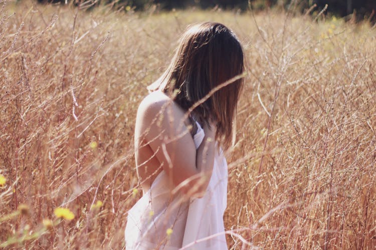 Woman Standing On Wheat Field Covering Her Body With White Cloth