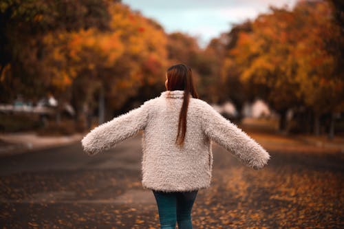 A Back View of a Woman in Off White Fur Coat 