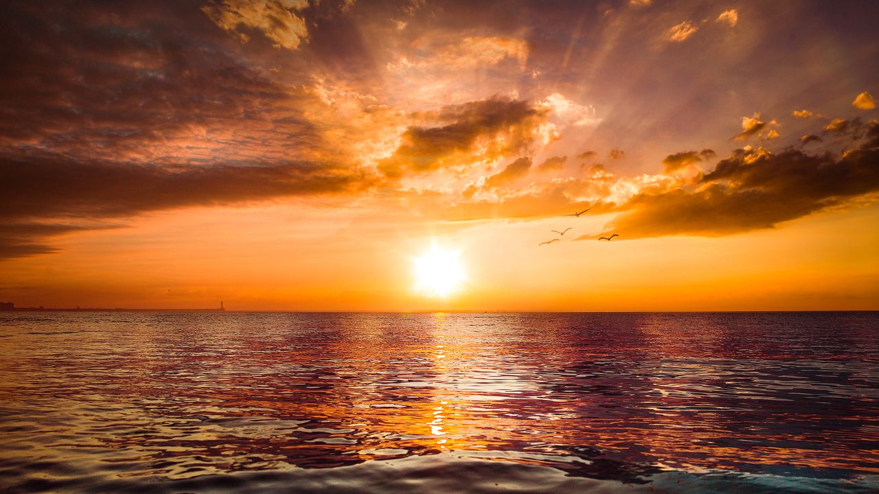 breathtaking sunset casting vibrant hues over calm ocean waters creati