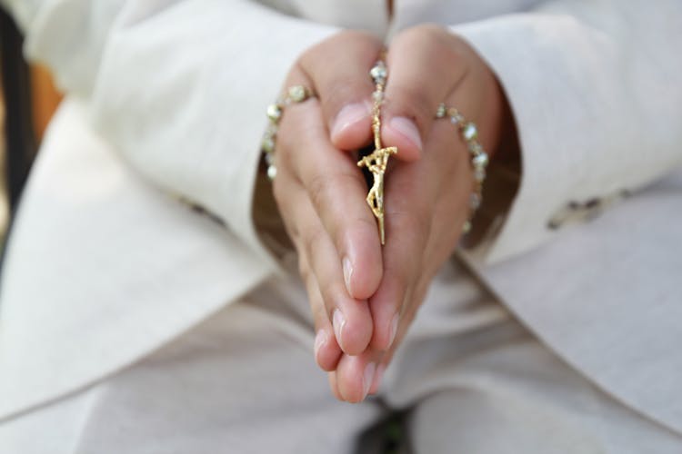 Hands Holding A Gold Rosary 