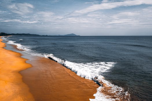 From above of foamy waves of rippling seawater rolling on wet sandy shore