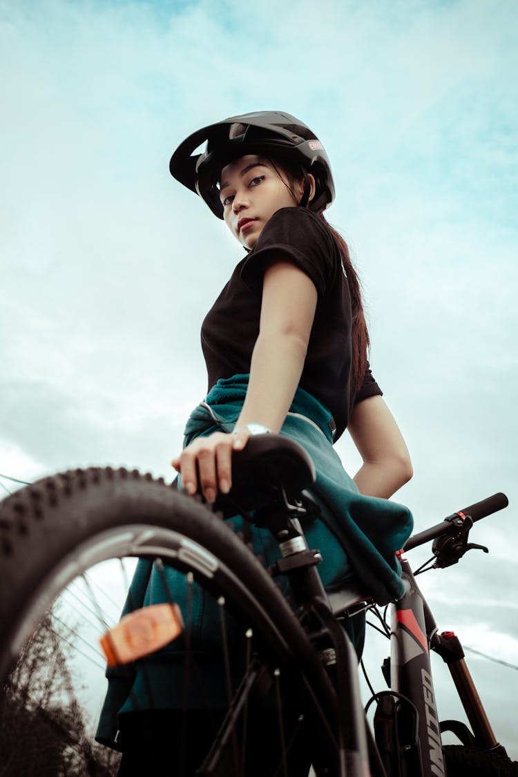 Woman Leaning On A Bicycle And Wearing A Helmet