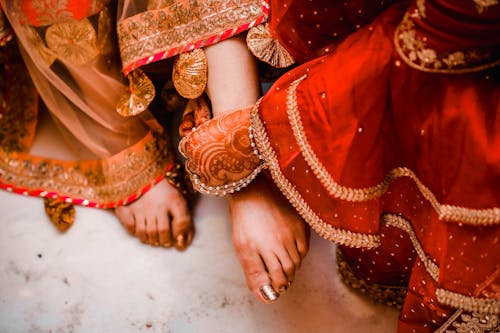 Free Women Showing Off Their Feet with Painted Nails and Henna Tattoos Stock Photo