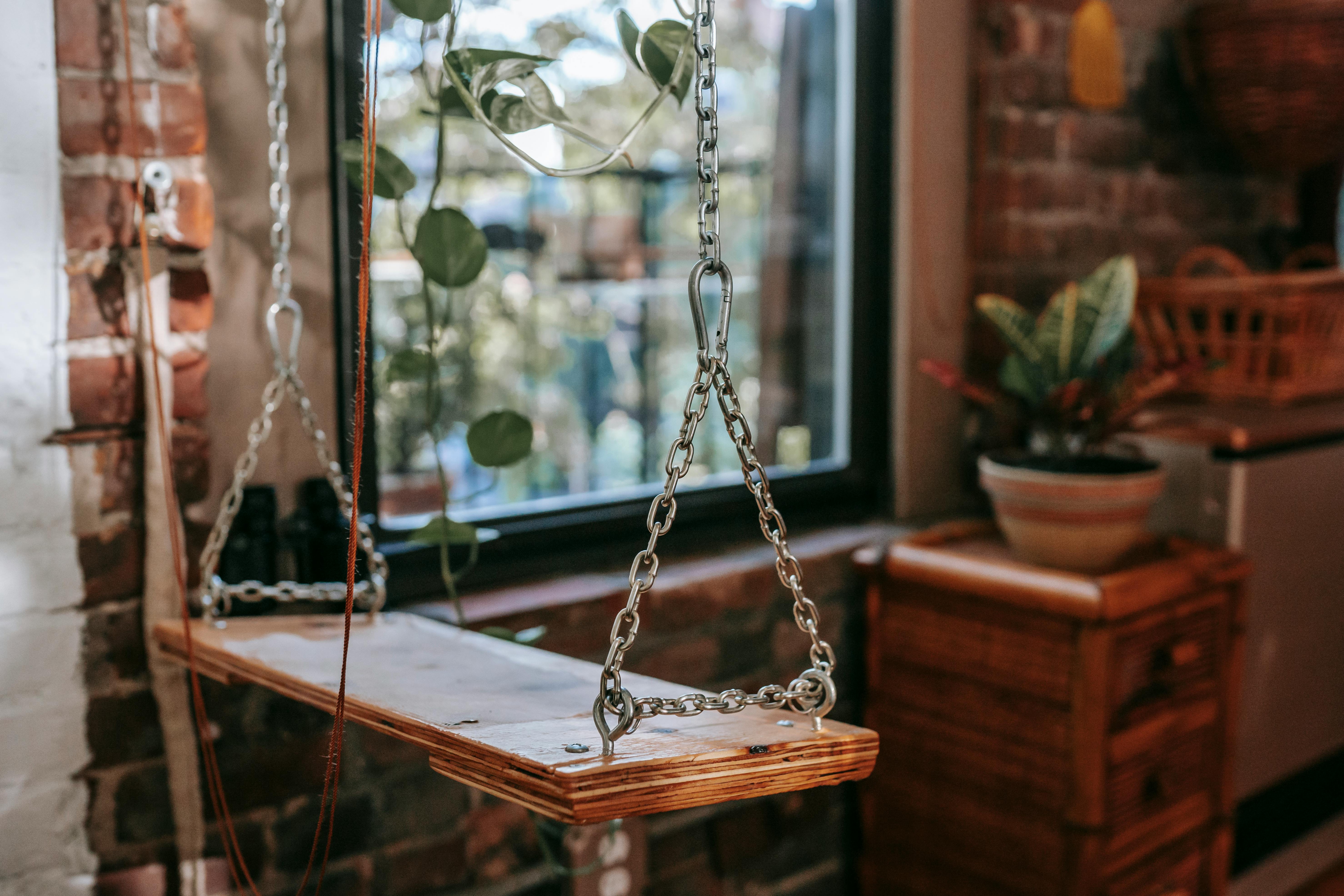 swing with metal chains in loft style house interior