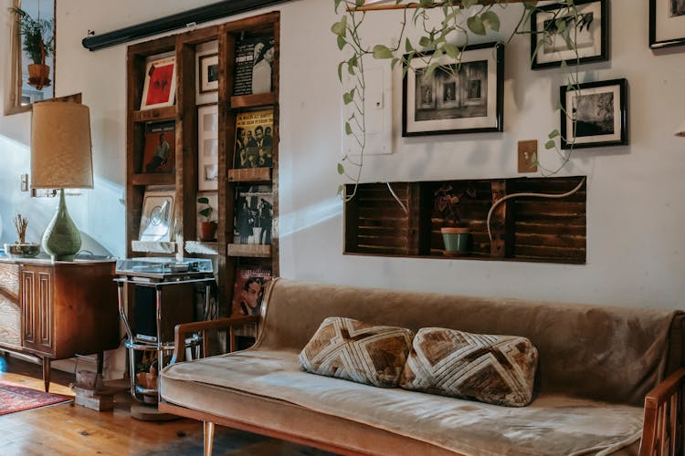 Shelf With Vinyl Records Collection Between Comfortable Sofa And Wooden Cabinet In Vintage Styled Room