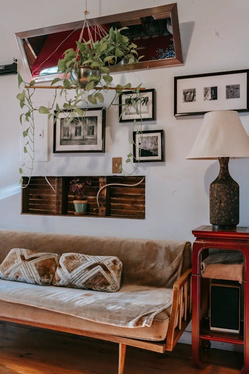 Sofa Dan Lemari Pajangan Kecil Dengan Lampu Elegan Di Dekat Dinding Dihiasi Gambar Berbingkai Di Rumah