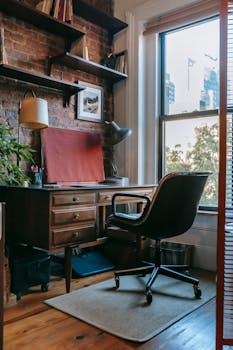 Comfortable room with shelves hanging on brick wall near large window in daylight