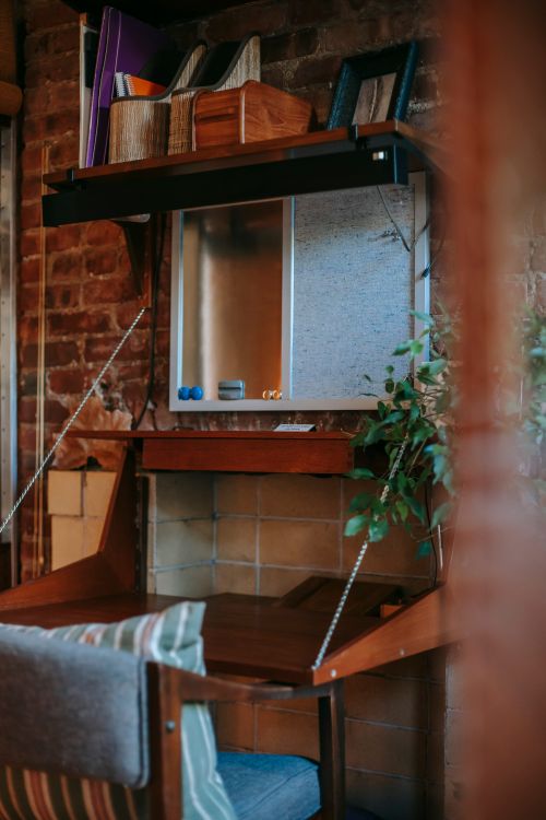 Free Interior of cozy room with wooden drop front writing desk with potted green plants in daytime Stock Photo