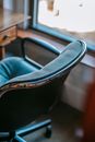 From above of soft office chair placed near wooden table in apartment in daylight