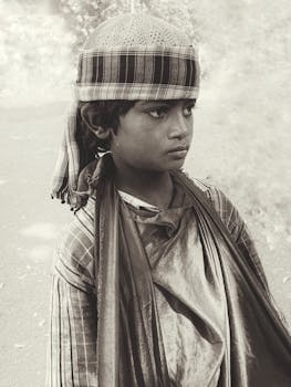 Sepia-toned portrait of a boy in traditional Indian clothing, wearing a headscarf in Nagur, Maharashtra.