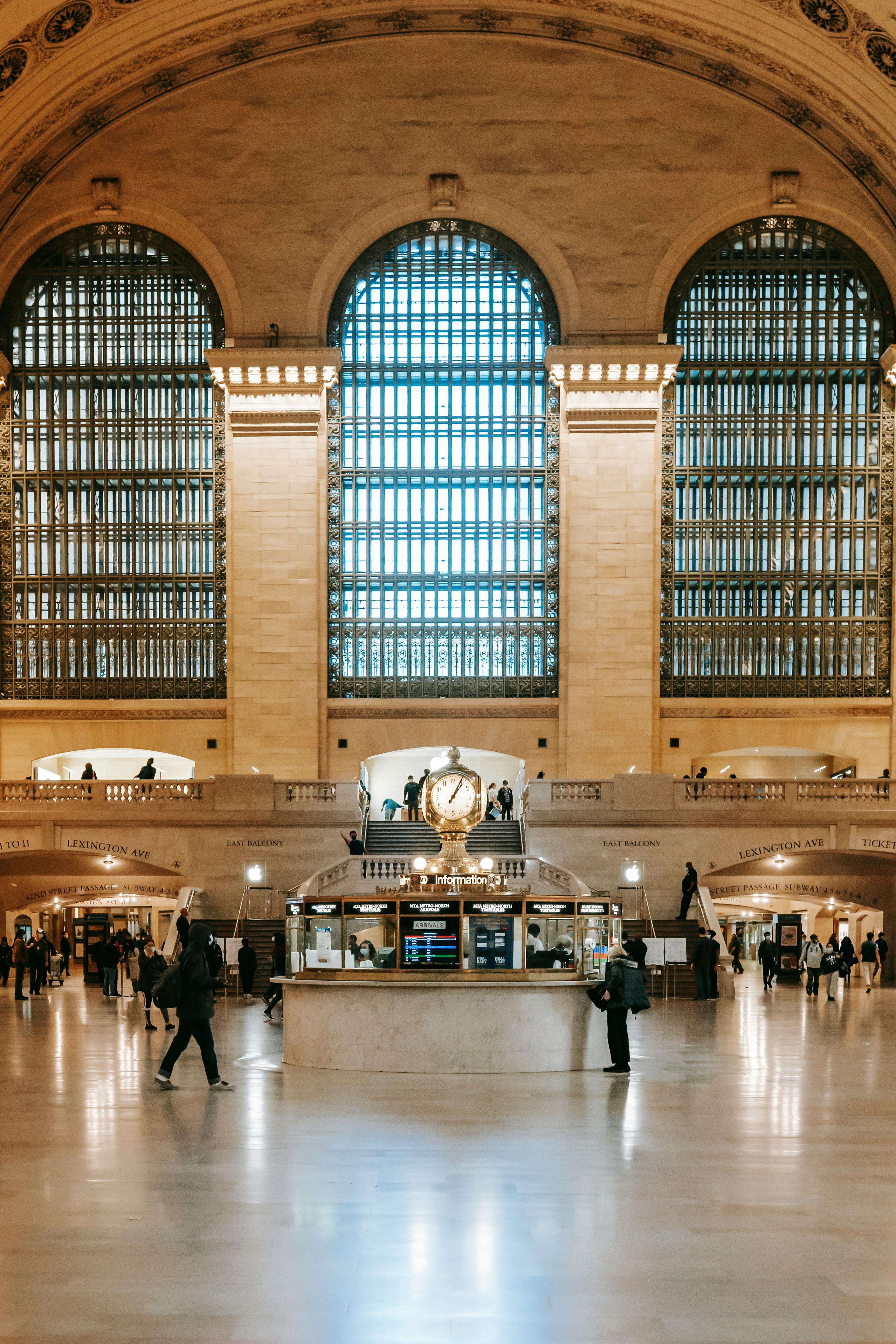 Interior view of Grand Central Terminal with its famous clock and arched windows, capturing commuters in motion.