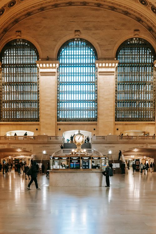 Free Interior view of Grand Central Terminal with its famous clock and arched windows, capturing commuters in motion. Stock Photo