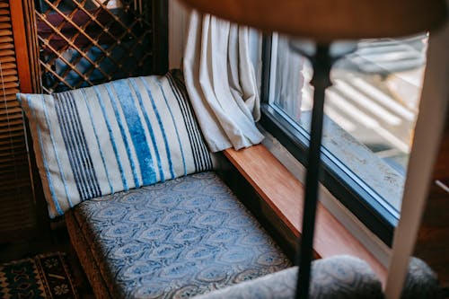 Free Interior of comfortable vintage room with couch and pillow under lamp near glass window Stock Photo