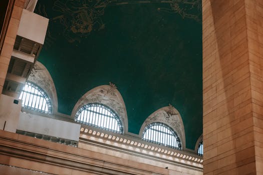 Low angle of classic stone museum with ornamental glass windows and decorated ceiling with painting