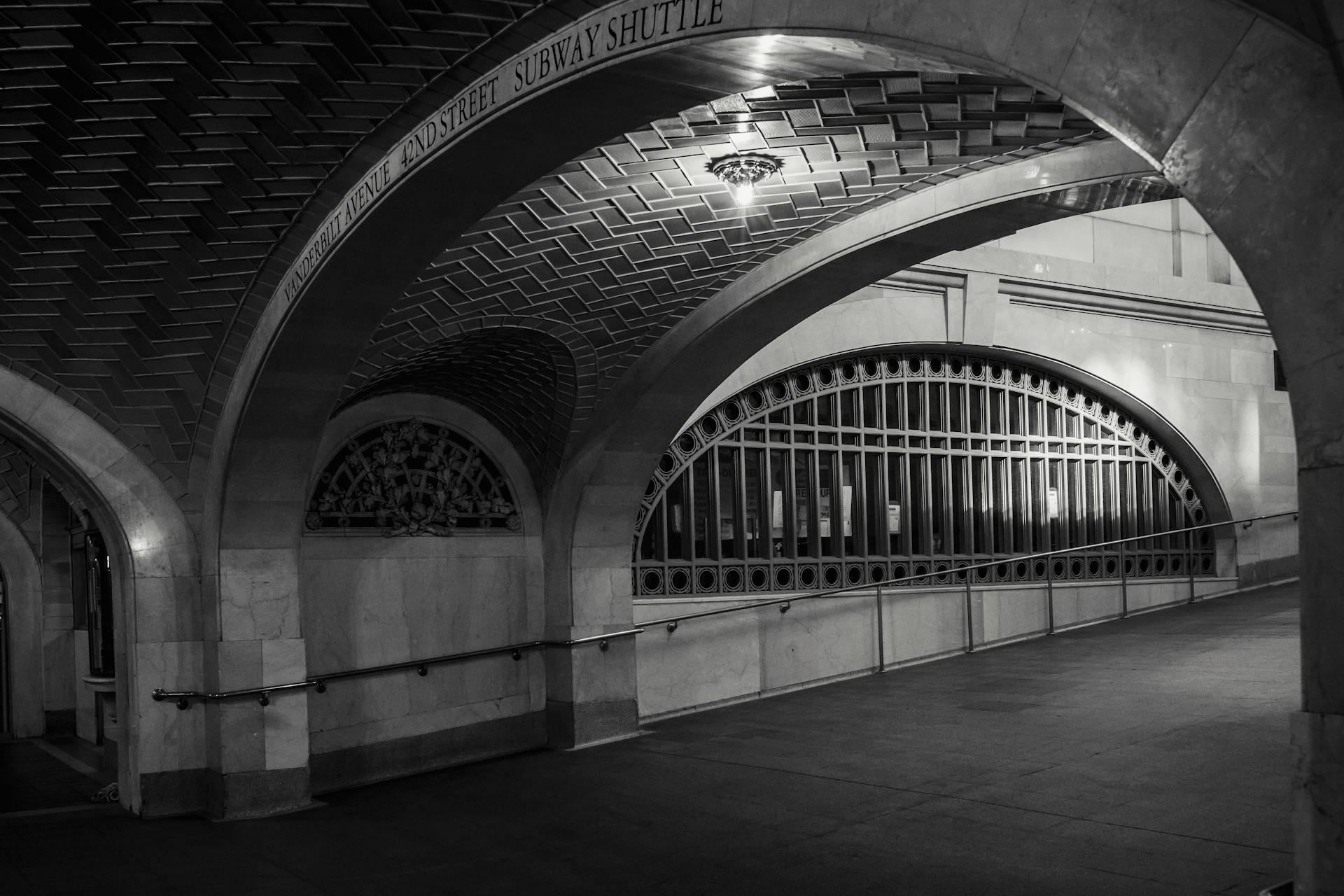 Black and white of old stone arched passage with classic interior and windows under lattice