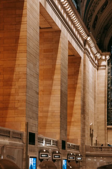 From below of famous hall decorated with wide square masonry columns in Grand Central Terminal station in New York USA