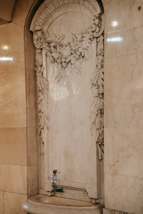 Free Classic marble drinking fountain under ornamental wall in room of old stone building Stock Photo