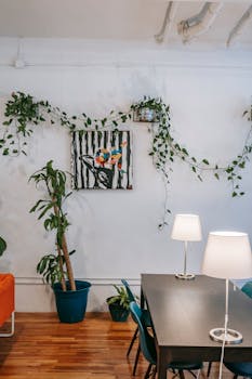Stylish living room with indoor plants and artwork, featuring cozy seating and modern decor.