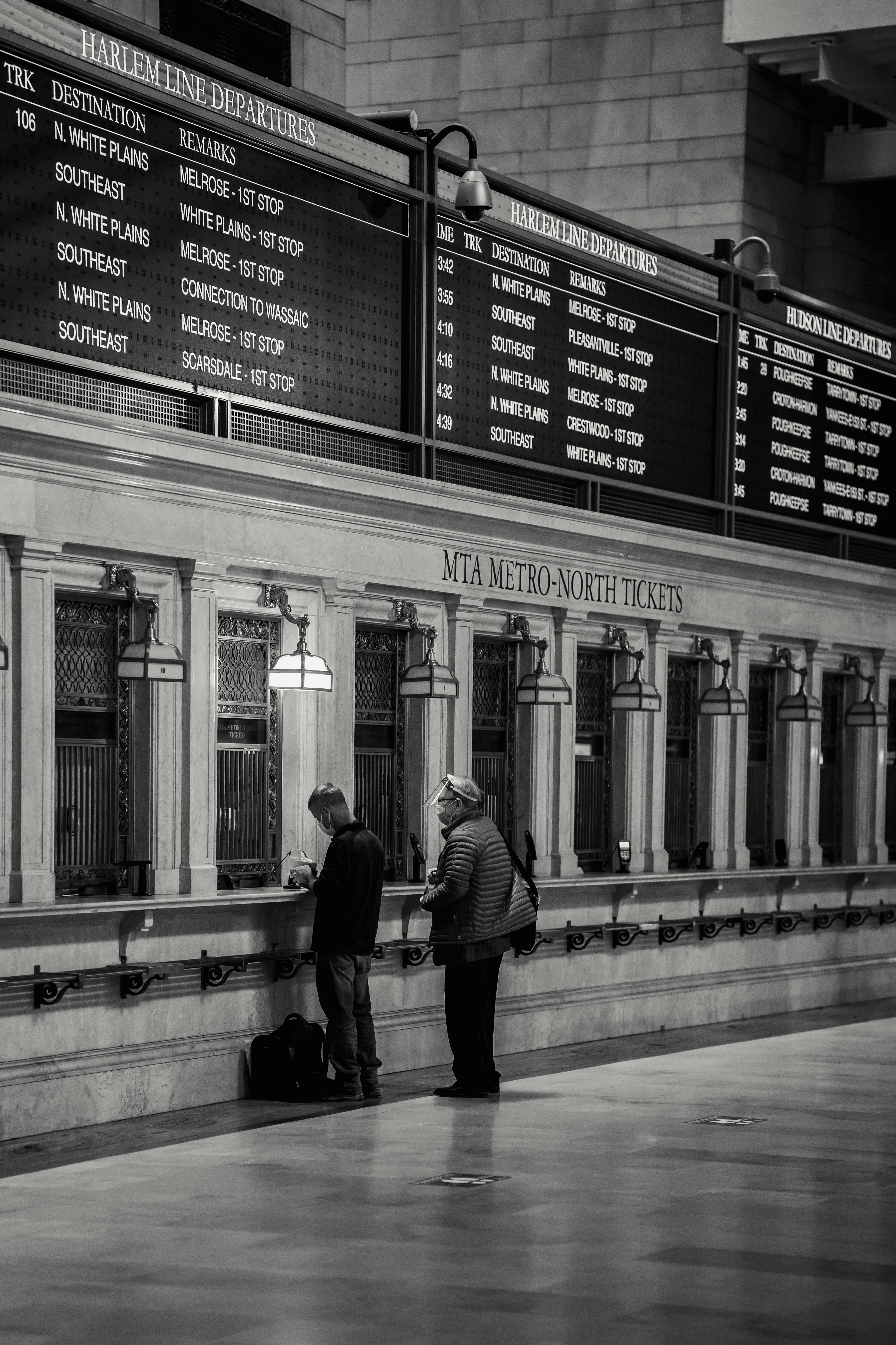 unrecognizable people buying tickets on train