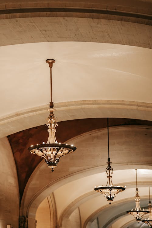 Free Low angle of aged stone rounded hall with chandelier with shiny lights in historic building Stock Photo