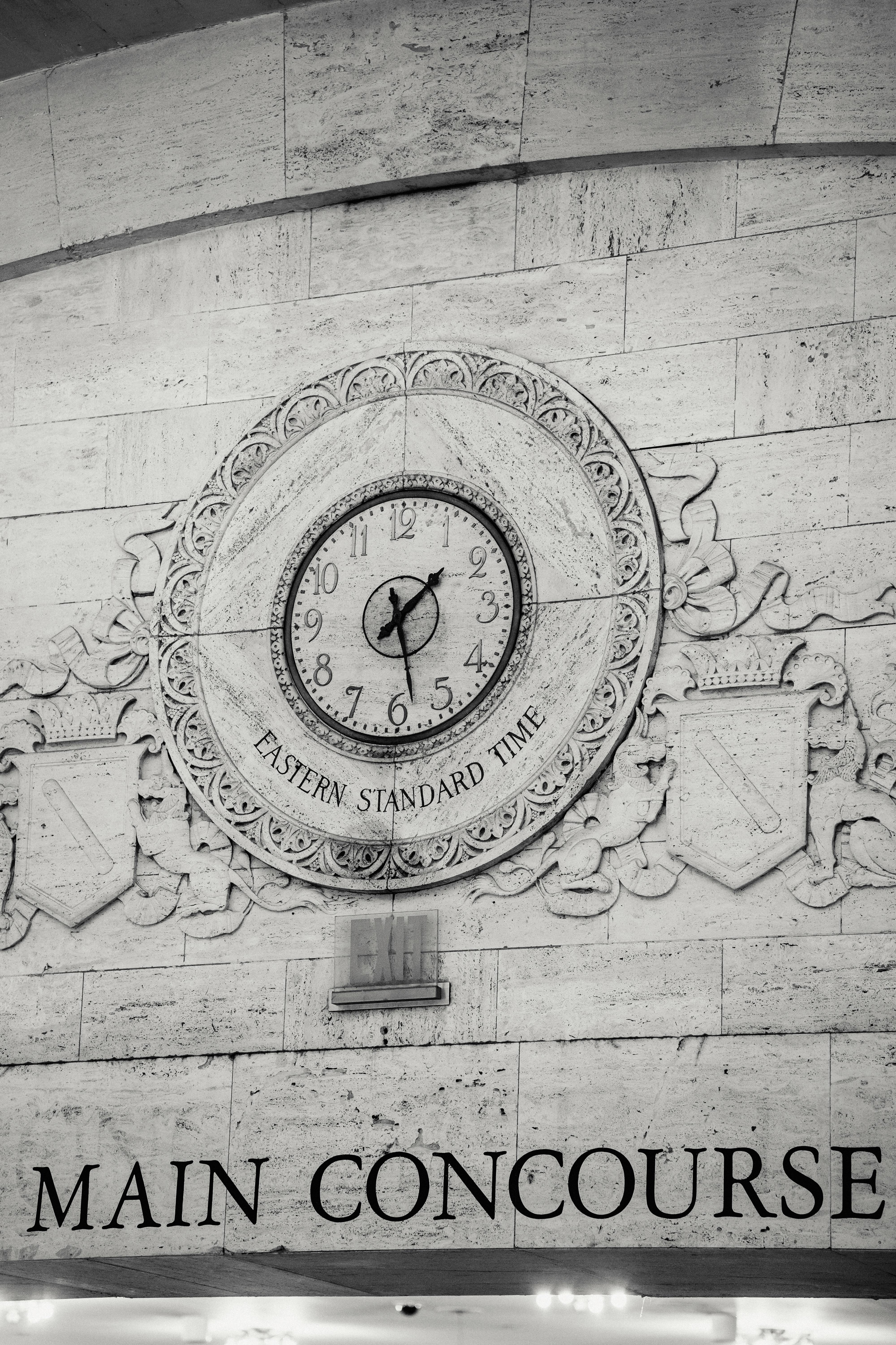 engraving of emblem with clock on stone wall