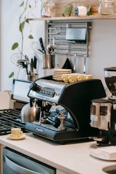Espresso machine with cups in cozy kitchen setting.