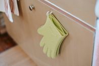 Pair of oven gloves on cabinet door in kitchen