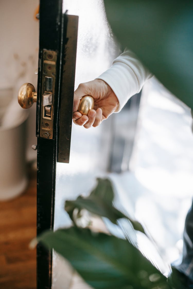 Crop Person Opening Building Door In Sunlight