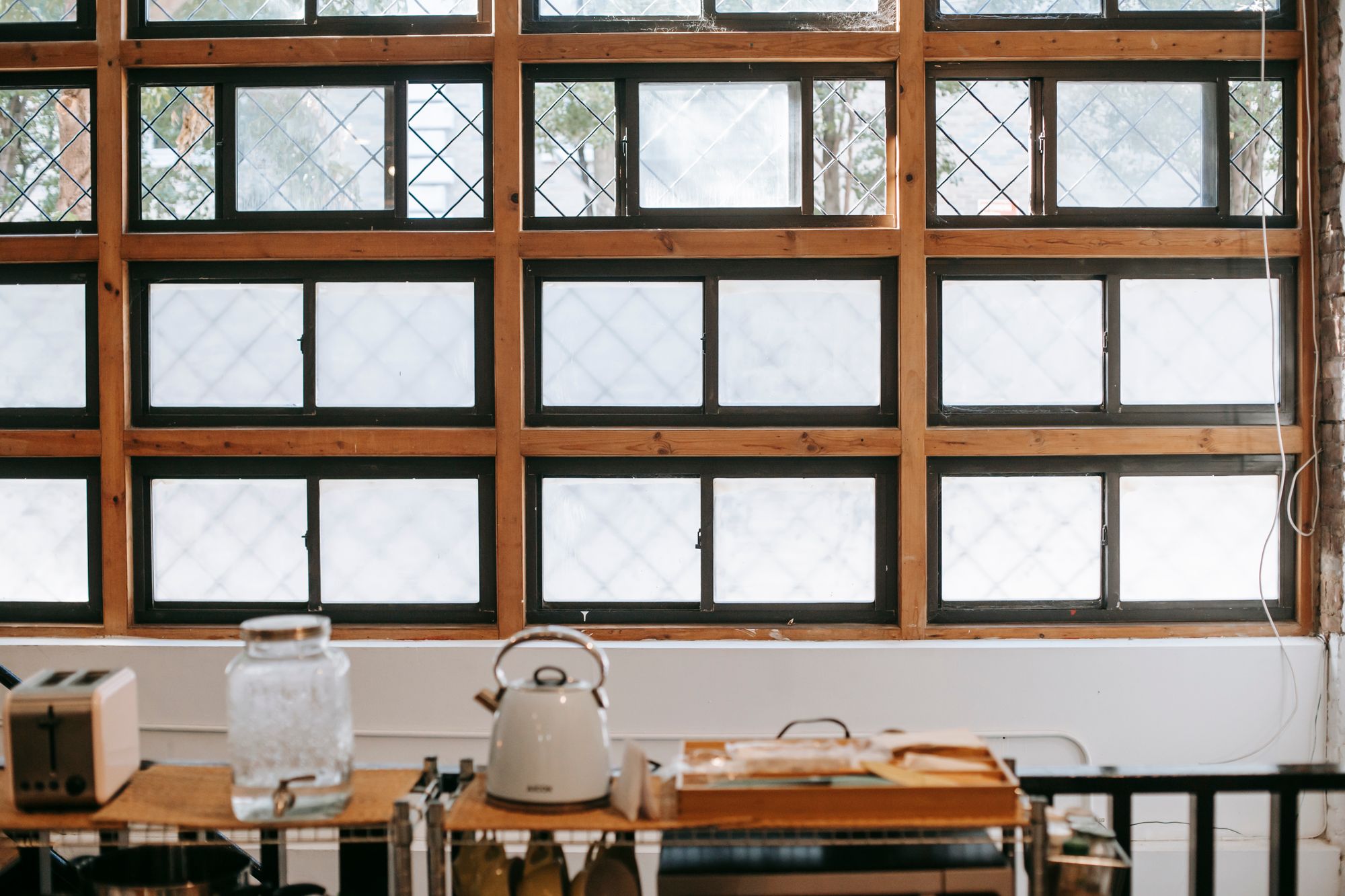 An electric kettle and toaster arranged beside a bright kitchen window for breakfast preparation
